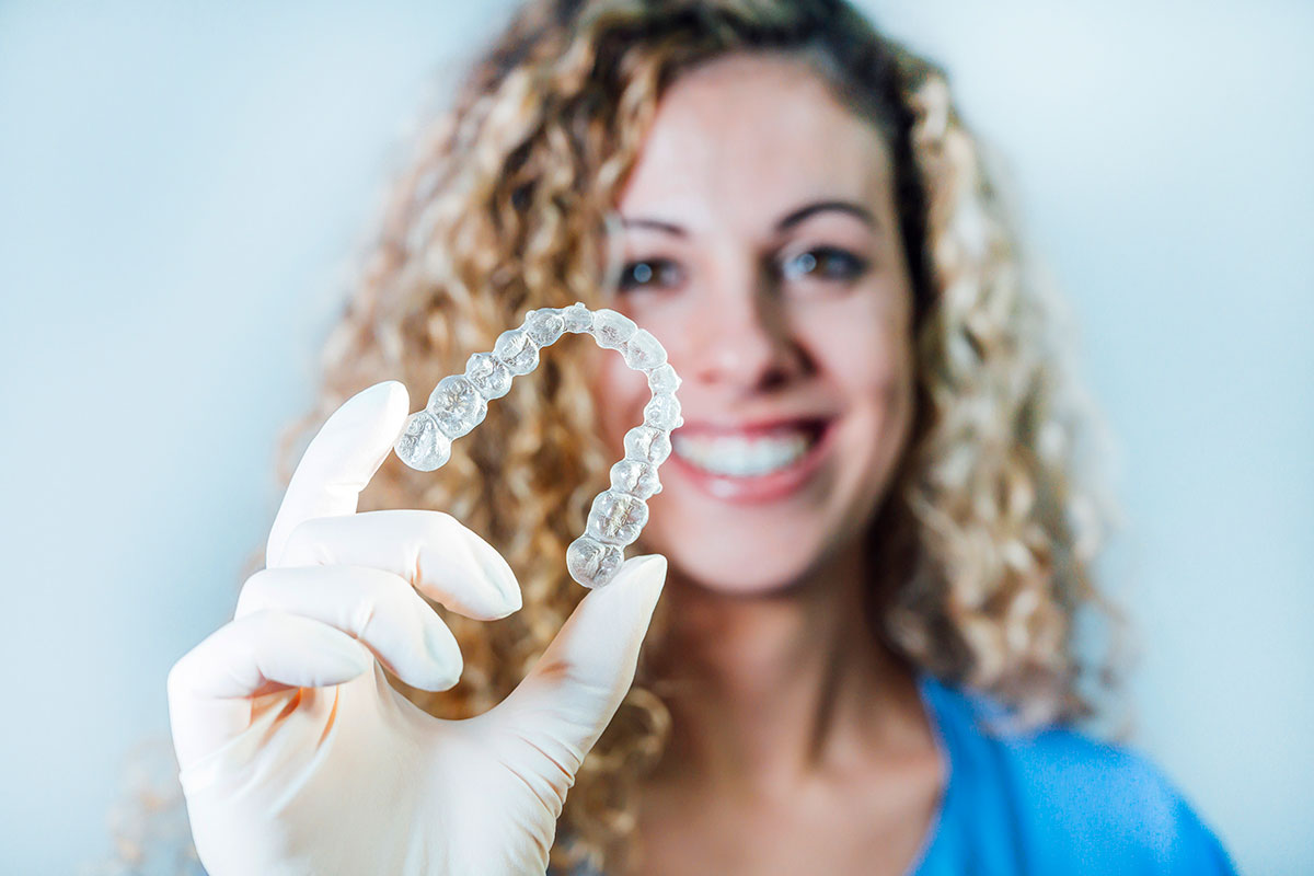 female doctor holding transparent dental aligner